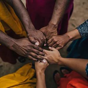 A group of five people joining hands in a circle, seen from above. - Minimax MiniMax Image-01