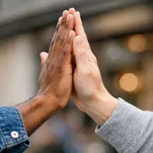 Two people high-fiving, with focus on their hands meeting mid-air. - OpenAI GPT Image 1.5