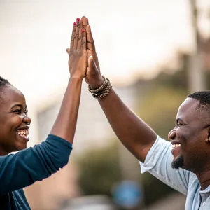 Two people high-fiving, with focus on their hands meeting mid-air. - Recraft Recraft V3