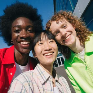 A group selfie of three friends of different ethnic backgrounds smiling at the camera. - Recraft Recraft V4.1