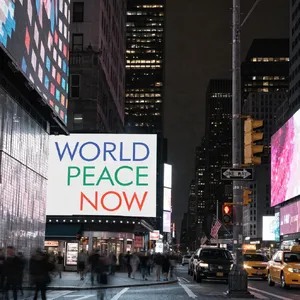A large storefront billboard at Times Square displaying the slogan “WORLD PEACE NOW” in bold, clear letters, amidst a vibrant cityscape at night. - Recraft Recraft V4.1