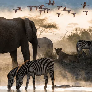 A misty dawn at an African savanna watering hole where elephants, lions, and zebras coexist in tense harmony, with a crocodile partially submerged in the foreground and flamingos taking flight in the background, golden hour lighting. - Recraft Recraft V4.1