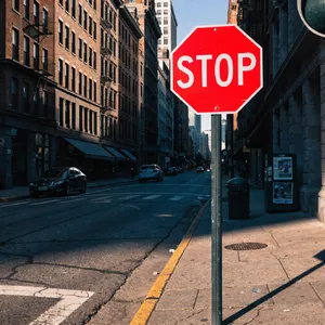 A red stop sign on a street corner displaying the word 