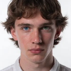 A studio headshot of a young man with one blue eye and one green eye (heterochromia). - Recraft Recraft V4.1