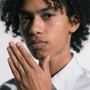 Photorealistic close-up portrait of a person clearly performing the American Sign Language gesture for 