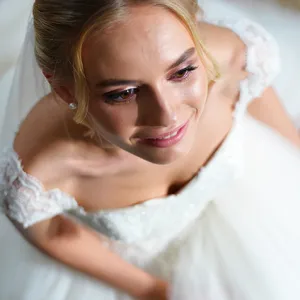 A bride on her wedding day, smiling with tears of joy in her eyes. - Reve Reve Image (Halfmoon)