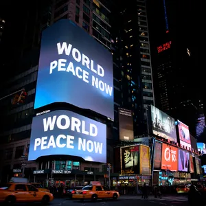 A large storefront billboard at Times Square displaying the slogan “WORLD PEACE NOW” in bold, clear letters, amidst a vibrant cityscape at night. - Reve Reve Image (Halfmoon)