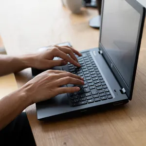 A person typing on a laptop keyboard, showing both hands on the keys. - Reve Reve Image (Halfmoon)
