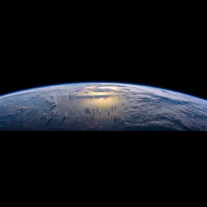 Photorealistic aerial photograph clearly showing the edge of the Earth from space, capturing realistic curvature, atmosphere, and sunlight reflections - Reve Reve Image (Halfmoon)