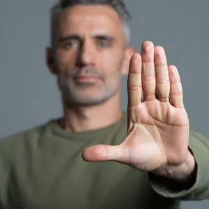 Photorealistic close-up portrait of a person clearly performing the American Sign Language gesture for 