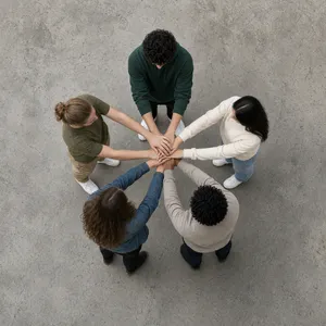 A group of five people joining hands in a circle, seen from above. - XAI Grok Imagine 2.0