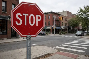 A red stop sign on a street corner displaying the word 