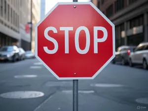 A red stop sign on a street corner displaying the word 