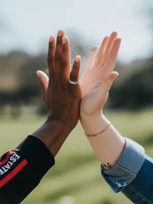 Two people high-fiving, with focus on their hands meeting mid-air. - XAI Grok Imagine (Quality)
