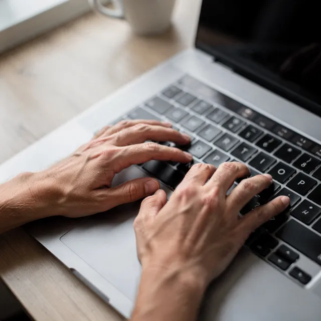 A person typing on a laptop keyboard, showing both hands on the keys - Black Forest Labs FLUX.2 Max