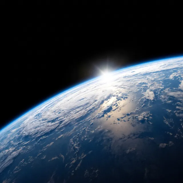 Photorealistic aerial photograph clearly showing the edge of the Earth from space, capturing realistic curvature, atmosphere, and sunlight reflections - Nano Banana Pro