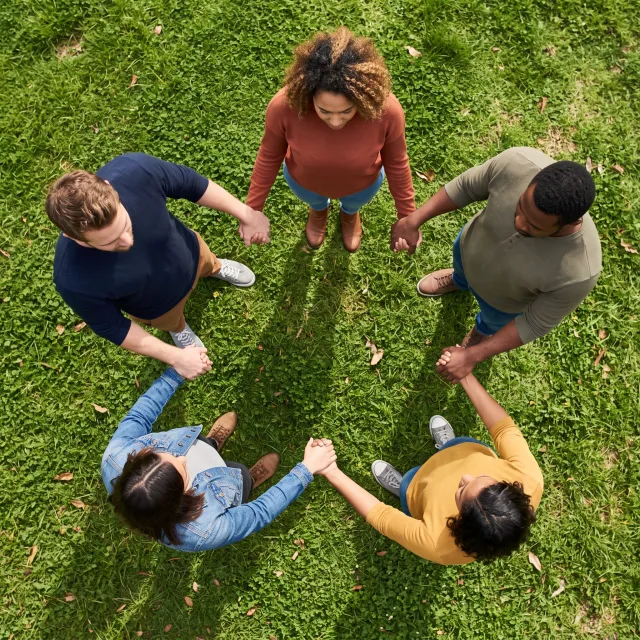 A group of five people joining hands in a circle, seen from above. - Nano Banana 2.1