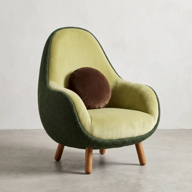 An armchair designed in the shape of an avocado, presented in a contemporary product photography style with professional studio lighting against a minimalist background. - Nano Banana 2.1