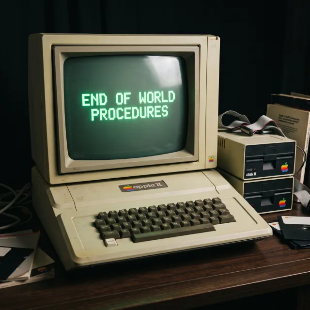 Vintage Apple II computer with green monochrome CRT screen, displaying 'END OF WORLD… - Google Nano Banana 2.1