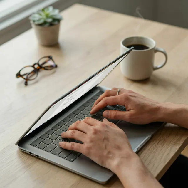 A person typing on a laptop keyboard, showing both hands on the keys - Ideogram 4.0 (Quality)