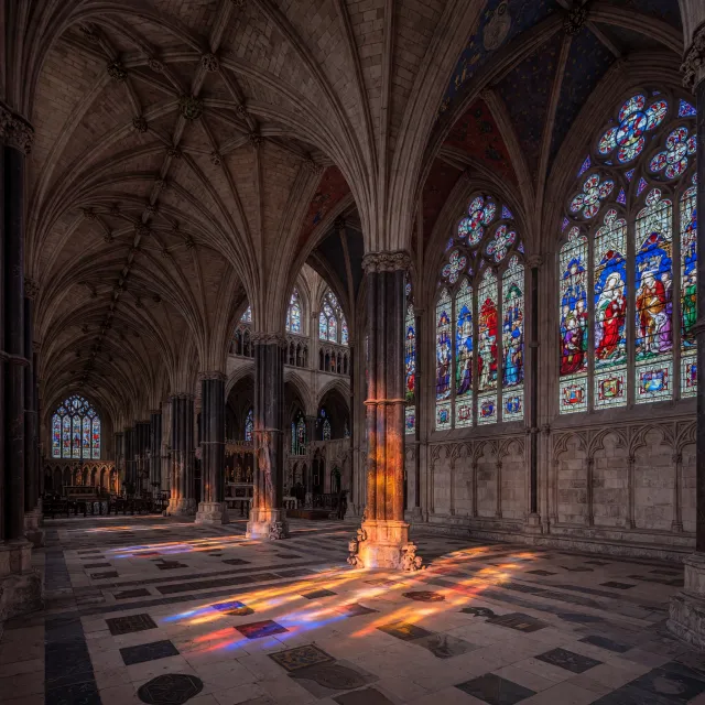 A Gothic cathedral interior at sunset with light streaming through detailed stained glass… - XAI Grok Imagine (Quality)