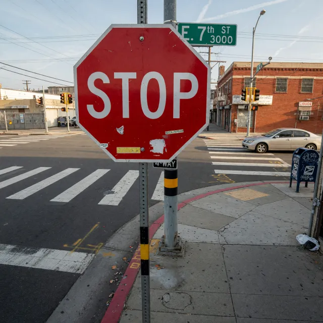 A red stop sign on a street corner displaying the word "STOP", photorealistic urban… - XAI Grok Imagine (Quality)