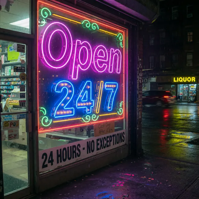 A storefront sign that says "Open 24/7" in neon lights, nighttime urban photography - XAI Grok Imagine (Quality)