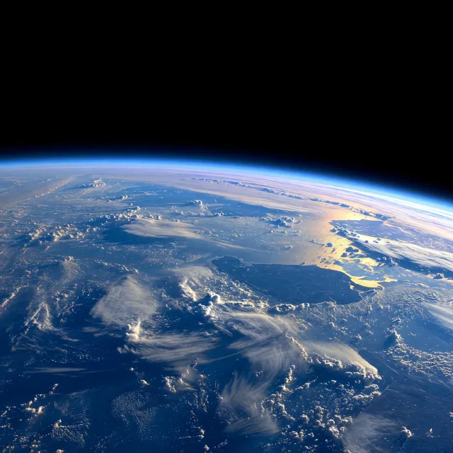 Photorealistic aerial photograph clearly showing the edge of the Earth from space, capturing realistic curvature, atmosphere, and sunlight reflections - Grok Imagine