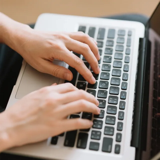 A person typing on a laptop keyboard, showing both hands on the keys - Bytedance Seedream 3.0