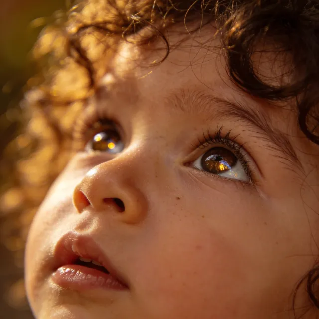 A hyper-realistic photo of a toddler with curly hair and big eyes, looking upward - Bytedance Seedream 4.5