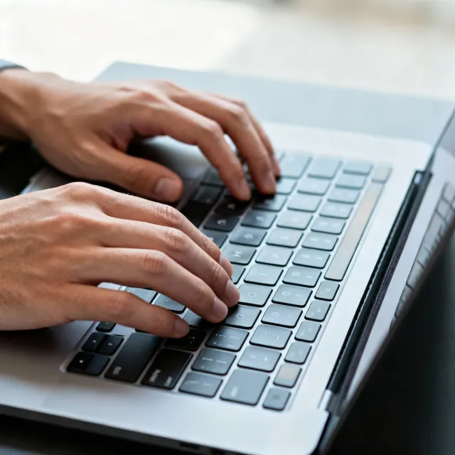 A person typing on a laptop keyboard, showing both hands on the keys - Bytedance Seedream 4.0