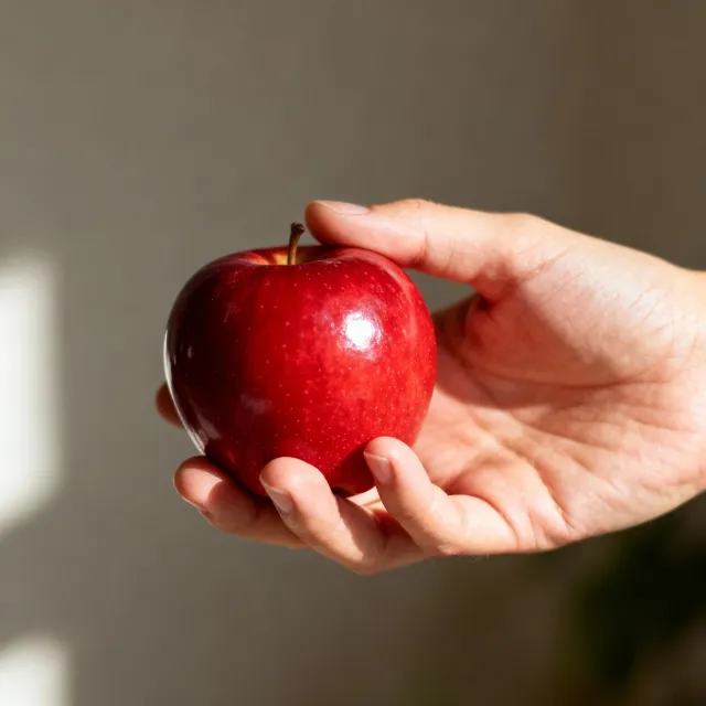 A realistic photo of a hand holding a red apple, with all fingers clearly visible - Bytedance Seedream 4.0