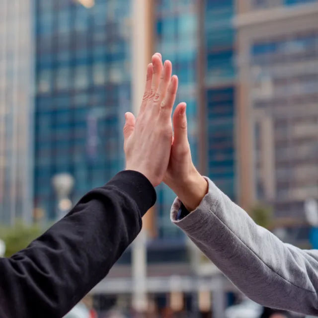 Two people high-fiving, with focus on their hands meeting mid-air - Ideogram V2