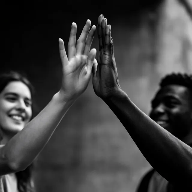 Two people high-fiving, with focus on their hands meeting mid-air - Krea 2 Large