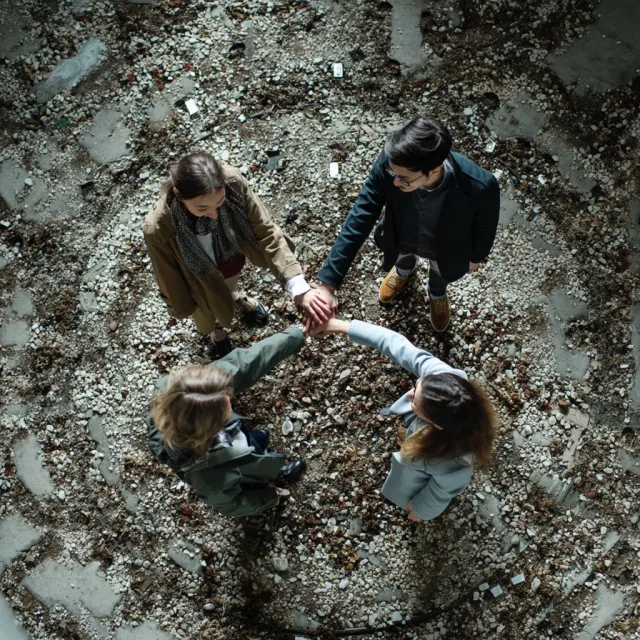 A group of five people joining hands in a circle, seen from above - Midjourney v7