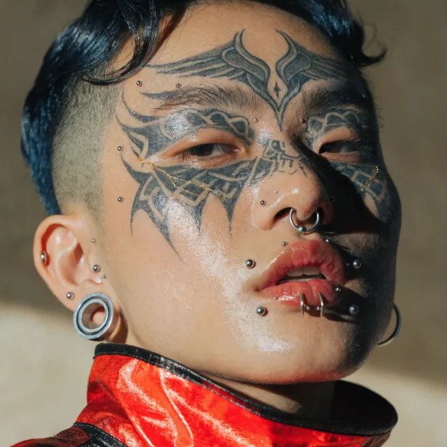 A portrait of a person with elaborate facial tattoos and piercings, shown in sharp detail - Recraft V4.1